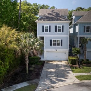 A house with a driveway and trees in the background