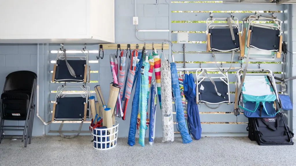 A bunch of umbrellas hanging up in the garage