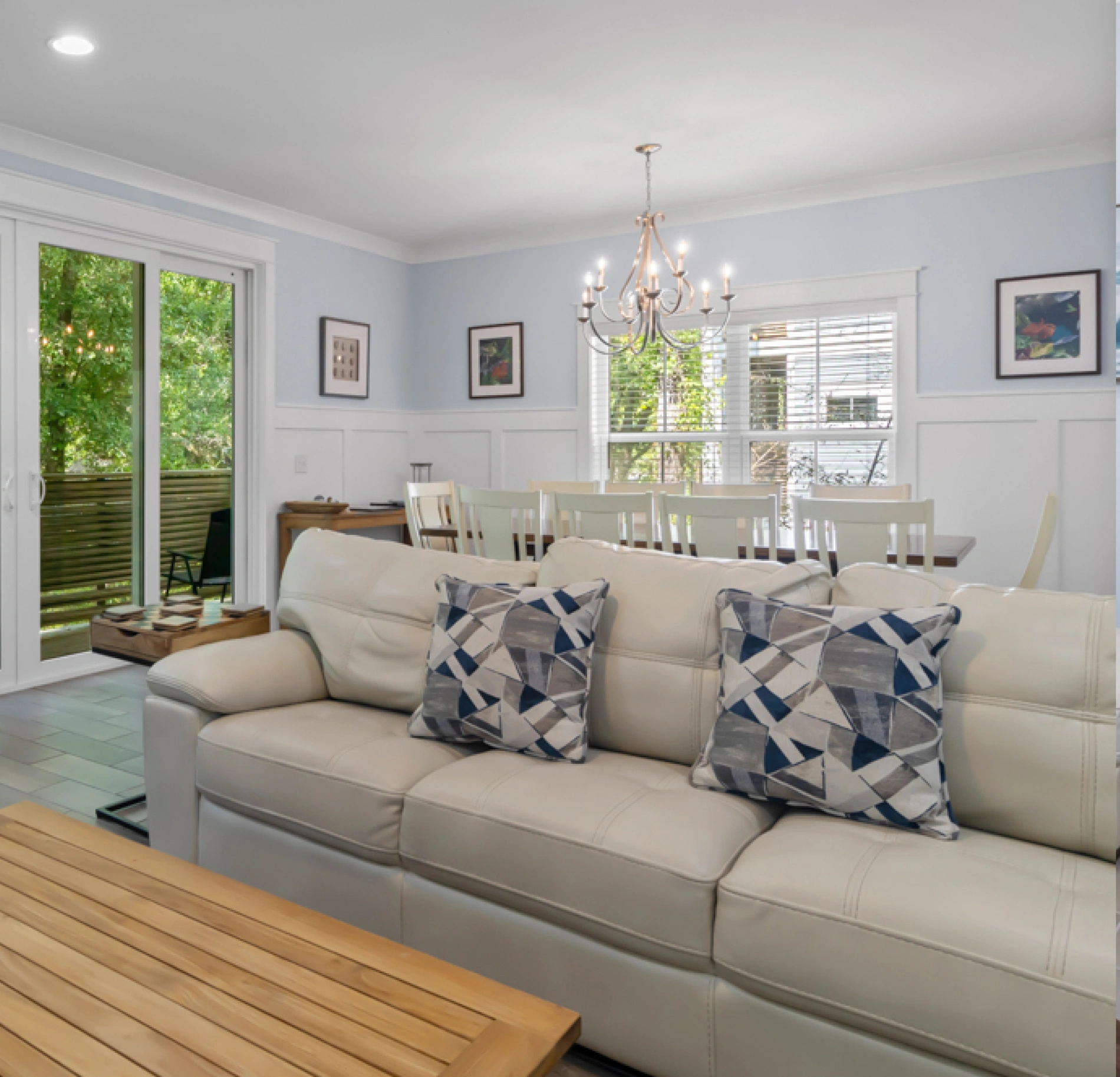 A living room with white furniture and a large window.