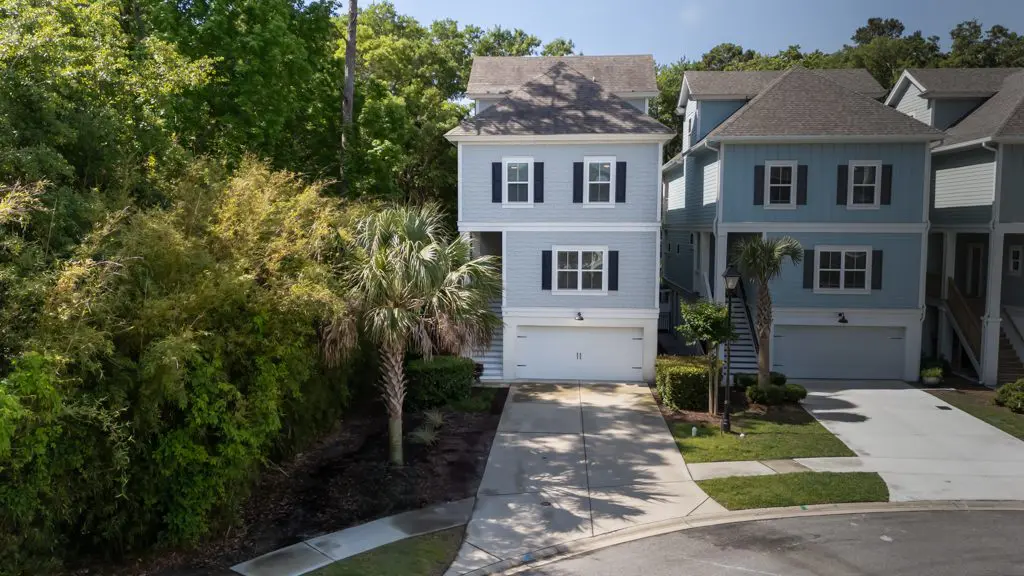 A house with a driveway and trees in the background