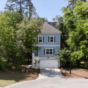 A blue house with trees in the background